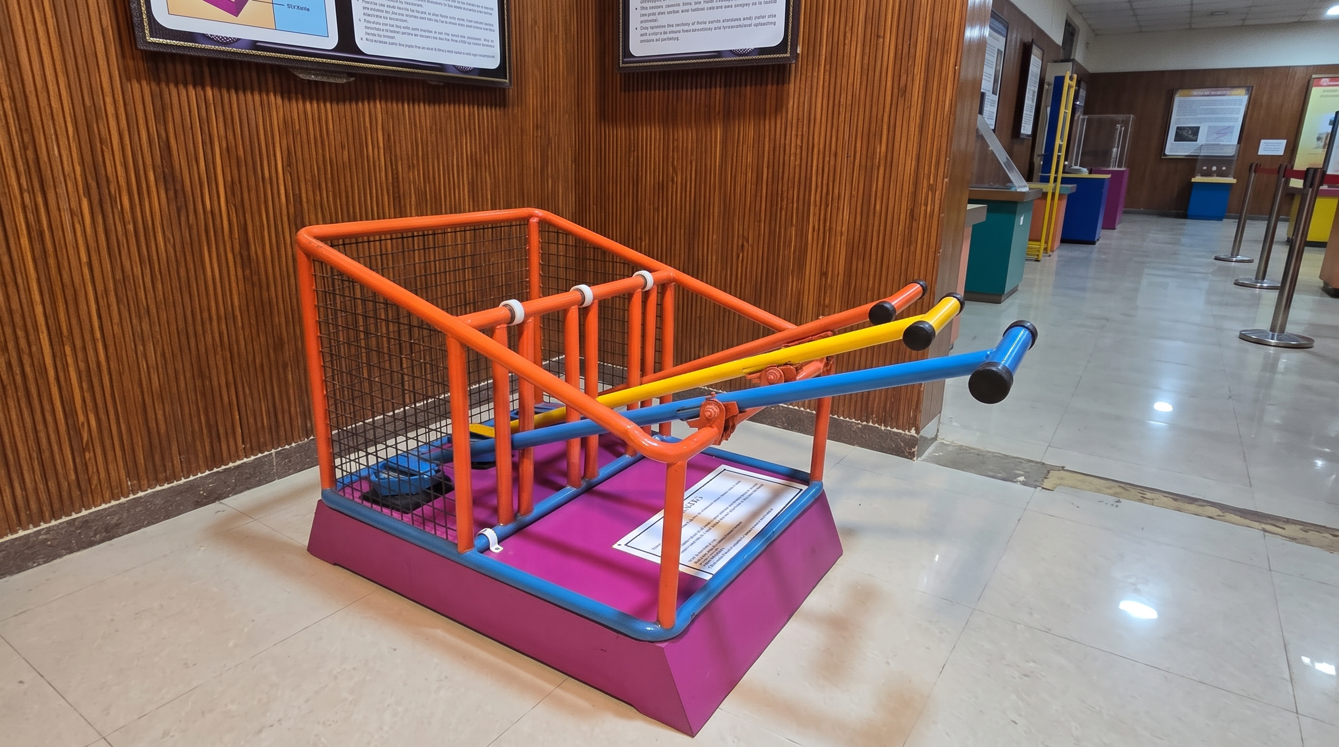 Concept visualisation of first-class mechanical levers exhibit showing color-coded tubular levers lifting load weights